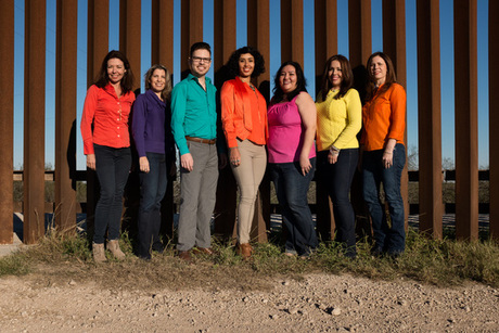 7 people in front of the border wall