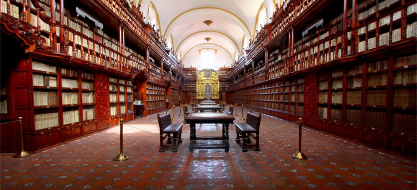 a picture of the inside of the oldest library in the americas. Stacked books on the sides